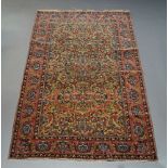 A Heriz rug, mid 20th Century, with overall floral design in a camel coloured field with red main