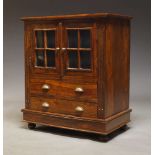 A hardwood and glazed cabinet, late 20th Century, with two glazed doors, over two drawers raised