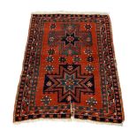 A Shirvan rug, early 20th century, with two star medallions in a deep red field, enclosed by