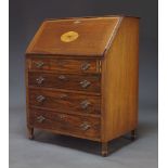 An Edwardian mahogany and line inlaid bureau, the fall with oval fan inlay, enclosing fitted