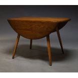 Ercol, a model 384 elm and beech drop leaf dining table, c.1960, the oval top on splayed square