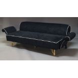 A modern black three seater sofa, late 20th Century, upholstered in black velvet with white trim