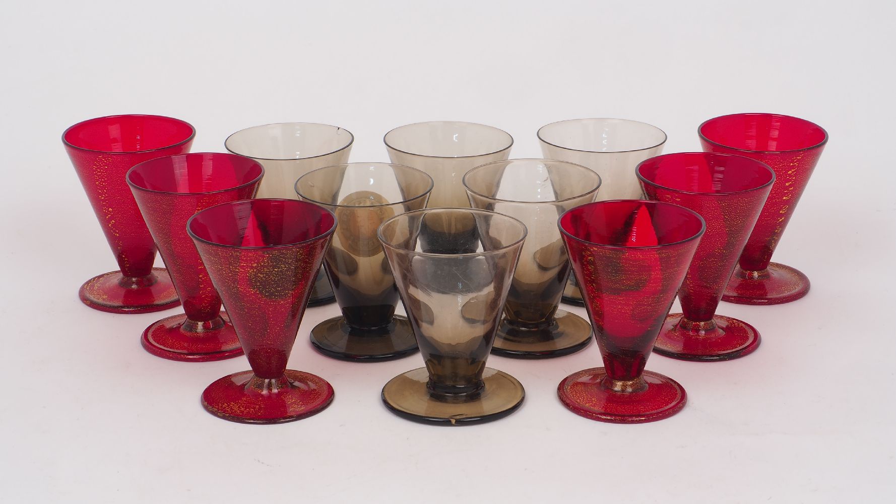 A set of six grey glass firing glasses, 20th century, of typical form, with conical bowls and flat