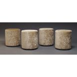 A set of four modern pouffes, of recent manufacture, of cylindrical form upholstered in fawn