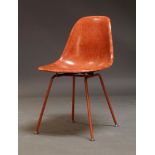 A red fibreglass shell chair, in the manner of Charles and Ray Eames by Modernica, Los Angeles, of