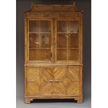 A Bamboo and glazed cabinet, c.1960, the pagoda top above two glazed doors enclosing two shelves,