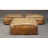 A set of three large leather upholstered poufs, of recent manufacture, comprising one square pouf