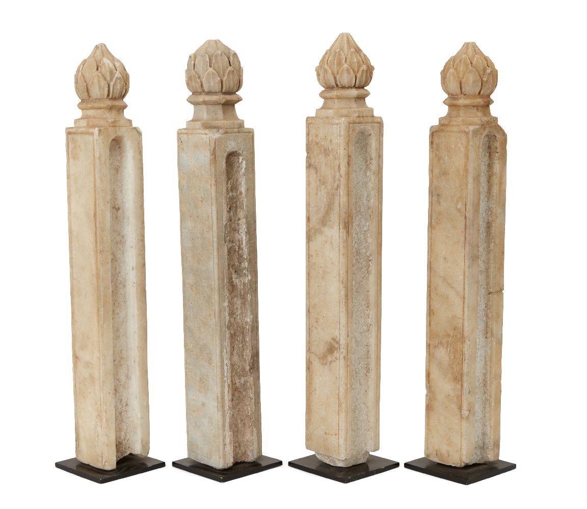 Four Mughal columnar shaped carved marble posts with finials in the shape of a closed lotus bud,