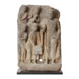 A Gandhara grey schist frieze, 2nd-3rd century, depicting Buddha with adorants, on a metal plinth,