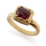 A ruby set square gold ring, South India, 19th century or earlier, the polished ruby pebble set
