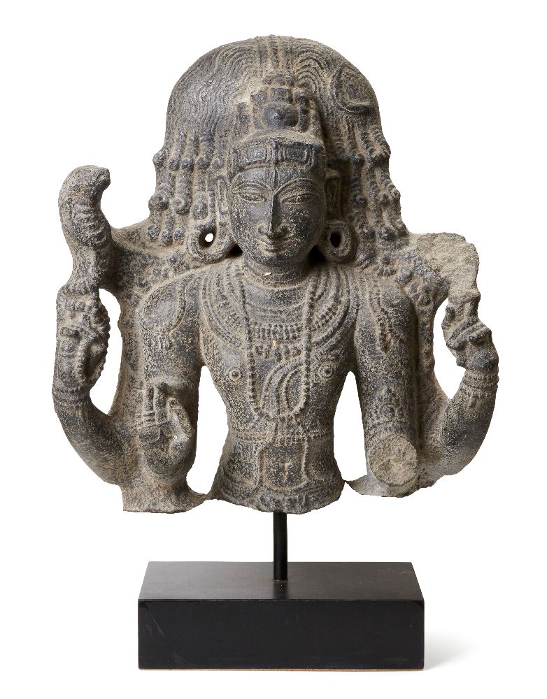 A black stone sculpture of Shiva, India, 19th century in a 10th century style, carved wearing a