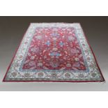 An oriental carpet with all over design of flowering foliate stems in a deep red field and ivory