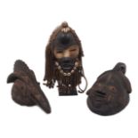 Three tribal masks, comprising: a Yoruba example, 40cm high, a Dan tribal mask with cowrie shells,