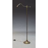 An adjustable brass standard lamp, early to mid 20th Century, the curved arm on height adjustable