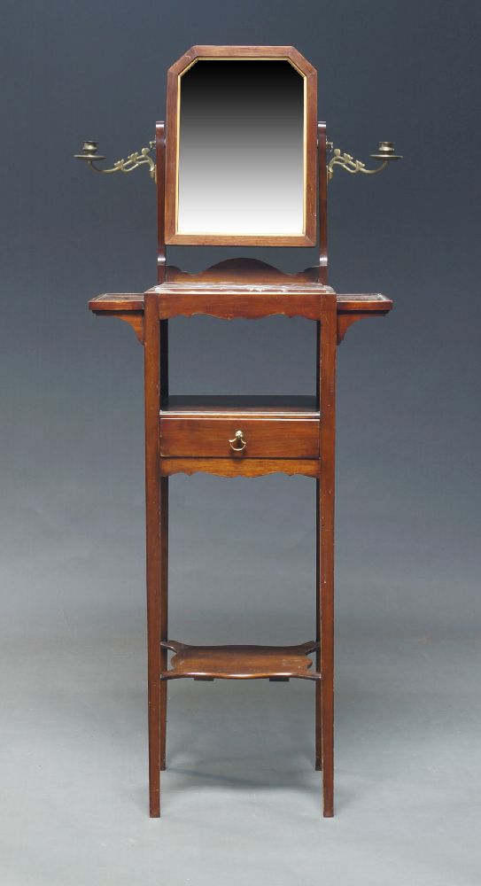 An Edwardian mahogany shaving stand, the top with dressing mirror flanked by two brass candle