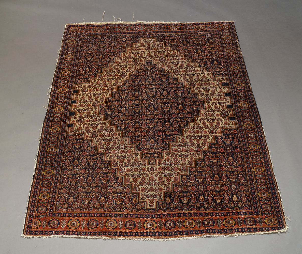 A Shiraz rug, early to mid 20th Century, with ivory lozenge in an ivory field with all over floral