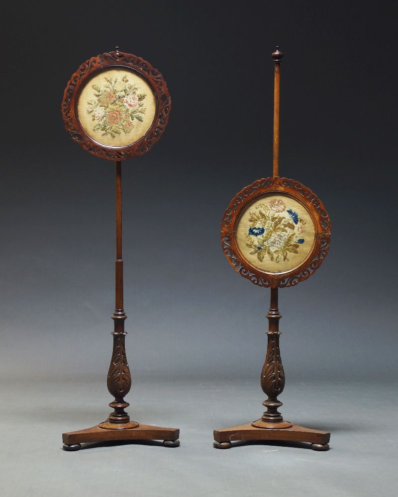 A pair of Victorian mahogany pole screens, with circular fretwork frames and glazed screens,