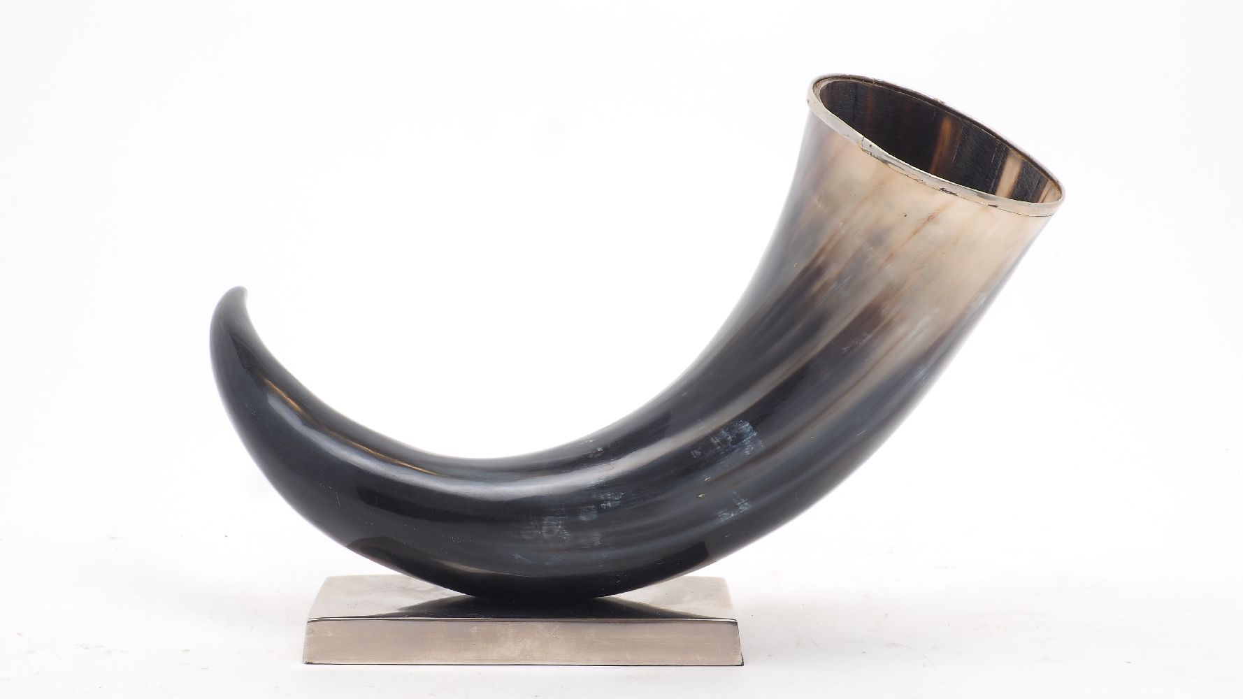 An ornamental ox drinking horn with white metal rim, mounted on a brushed metal base, 25cm high,