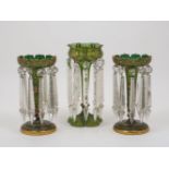 A pair of Victorian green glass table lustres, with castellated rim and tapering knopped stem to