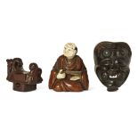 Three Japanese wood netsuke, 19th century, carved as Hotei and Karako playing Go; an Okina Noh mask;