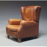 A modern leather reclining lounge chair, c.1970, upholstered in tan leather, with reclining backrest