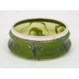 A Loetz style green glass bowl, early 20th century, with plated mount, 8cm high, 21cm diameter
