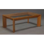A modern cherry wood and glazed coffee table, the rectangular glazed top on chamfered angled