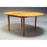 A Danish teak extending dining table, c.1960, the rounded top with central fold out leaf, on