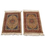 A near pair of silk Hereke rugs, mid to late 20th century, the terracotta flowerhead pole