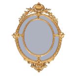 A Louis XV style giltwood oval marginal mirror, early to mid 20th century, the crest with carved