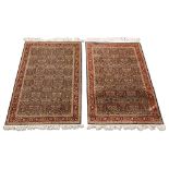 A pair of Hereke Millefleurs silk rugs, mid to late 20th century, with repeating floral and