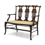 A late Victorian mahogany, fruitwood and ivory inlaid two seat settee, the shaped backrest with