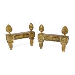 A pair of Louis XVI ormolu chenets, late 18th century, each with scrolling foliate frieze mount