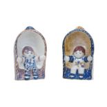 Two Royal Copenhagen faience figures of children, 20th Century, each figure seated within half-