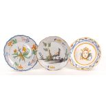 A group of three faience plates, 18th / 19th Century, comprising a Delft style deep plate with a