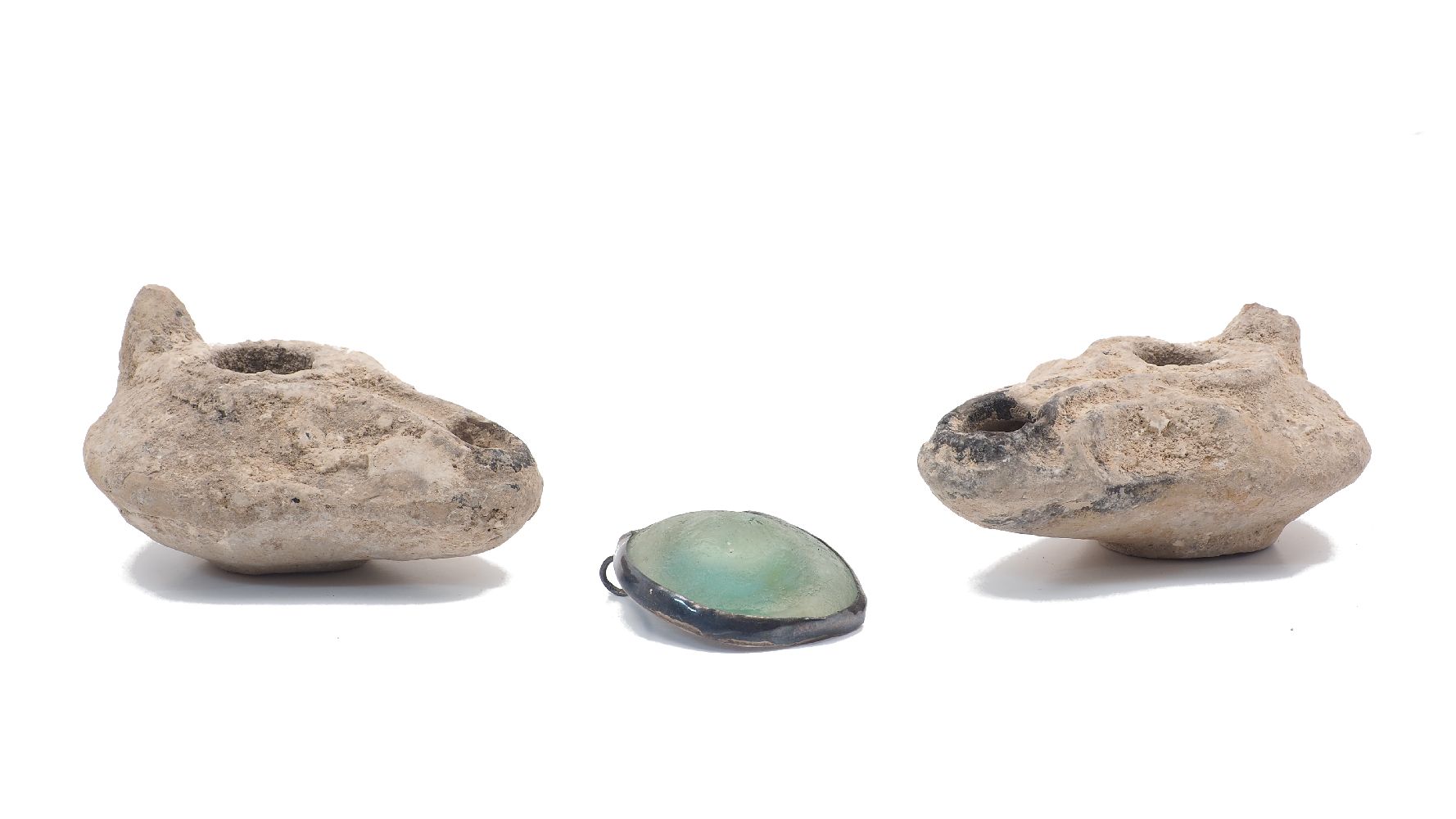 Two Roman style pottery oil lamps, 20th Century, 7cm and 8.5cm long, together with a turquoise glass