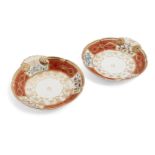 A pair of Sevres style orange and white ground dishes, with gilt scalloped rims and a trio of floral