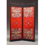 A Chinese ebonised two fold screen, 20th Century, with red felt panels embroidered with floral