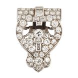 An Art Deco platinum and diamond clip brooch, of openwork stylised shield shaped design set