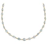 An aquamarine necklace, composed of a line of oval and circular-cut aquamarine collets with twin