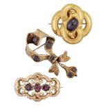 Three Victorian gold and garnet brooches, comprising: one of looped quatrefoil design with central