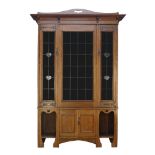 An Art Nouveau oak bookcase, c.1905, The moulded cornice surmounted by arched panel with pierced