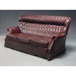 A burgundy leather button back sofa suite, late 20th Century, to include a three-seater sofa, 91cm