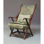 A late Victorian mahogany X-framed upholstered open armchair, circa 1890, possibly retailed by
