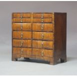 A George I and later walnut chest of drawers, circa 1720, fitted with four small drawers and eight