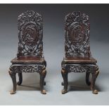 A pair of Chinese carved hardwood chairs, late 20th Century, overall decorated with carved