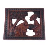 A carved African hardwood panel, 20th Century, depicting two figures in a forest environment, within