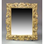 An early 19th Century carved giltwood mirror, in the Baroque style, symmetrically carved with