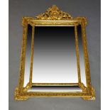 A late 19th Century gilt framed wall hanging mirror, in the Baroque style, the top with a shell