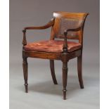 A Regency period mahogany canework open elbow chair, circa 1820, of pegged mortise and tenon